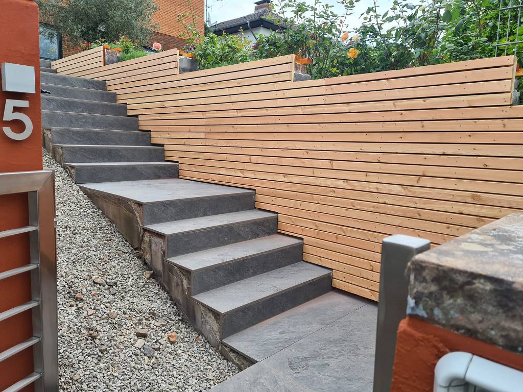 Treppenaufgang mit seitlicher Holzverkleidung.